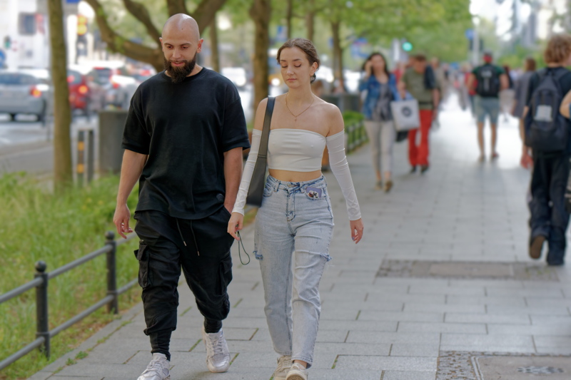 30 - Young couple casually walking down a city sidewalk